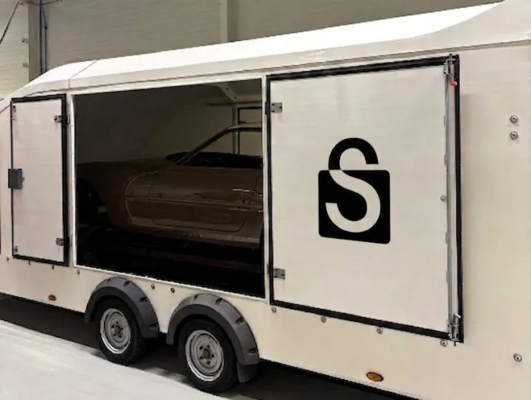 A Sealed by RM Sotheby's enclosed trailer with a car inside